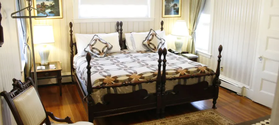 A guest room with a carved four-poster bed
