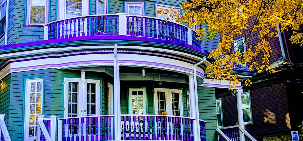 The purple-trimmed Victorian guest house with its curved balcony and autumn foliage